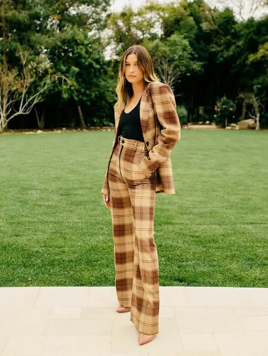 Tampil memesona di tengah hamparan rumput hijau, Hailey Bieber mengenakan one set suit dari kwaidan editions. (FOTO: Instagram/stylememaeve).