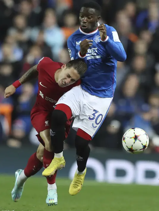 Bek Liverpool, Kostas Tsimikas berebut bola dengan pemain Rangers, Fashion Sakala pada pertandingan lanjutan Grup A Liga Champions di stadion Ibrox di Glasgow, Skotlandia, Kamis, 13 Oktober 2022. Dengan kemenangan ini, Liverpool kin berada di peringkat kedua klasemen dengan 9 poin. (AP Photo/Scott Heppell)