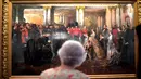 Ratu Inggris Elizabeth II melihat lukisan Ratu Victoria yang sedang memeriksa Penjaga Coldstream tahun 1855 karya John Gilbert sebagai bagian dari pameran di Istana Buckingham, London, Rabu (17/7/2019). Pameran tersebut menandai peringatan 200 tahun kelahiran Ratu Victoria. (AP Photo/Frank Augstein)