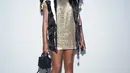 Pemain tenis asal Amerika Serikat Venus Williams tampil glamor dalam balutan glitter dress dan vest.  Penampilannya pun semakin terlihat stunning dalam knee length boots warna cokelat. (Dok/Louis Vuitton).