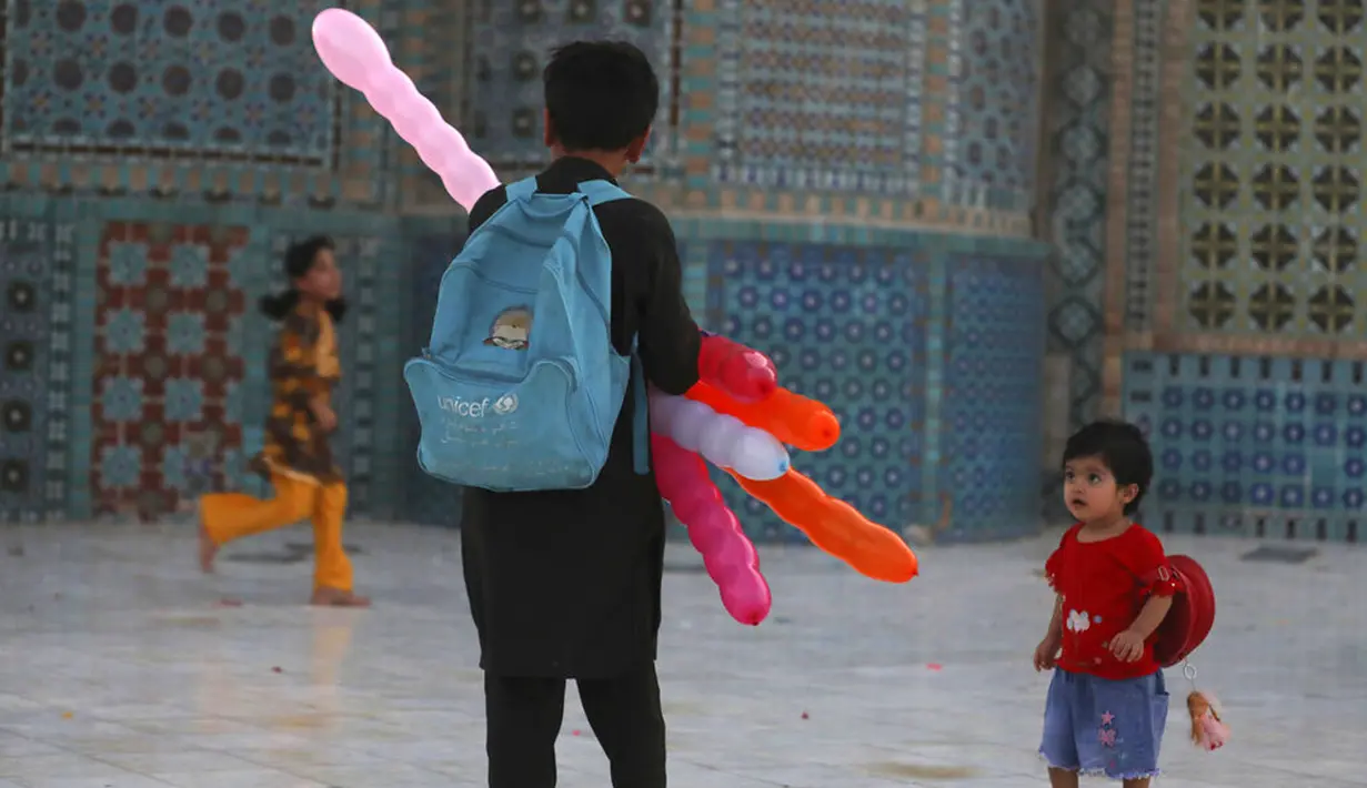 Anak-anak mengunjungi Hazrat-e-Ali atau Masjid Biru di Mazar-e-Sharif, Afghanistan, Rabu (7/7/2021). Masjid Biru adalah ikon bangunan megah di Afghanistan. (AP Photo/Rahmat Gul)