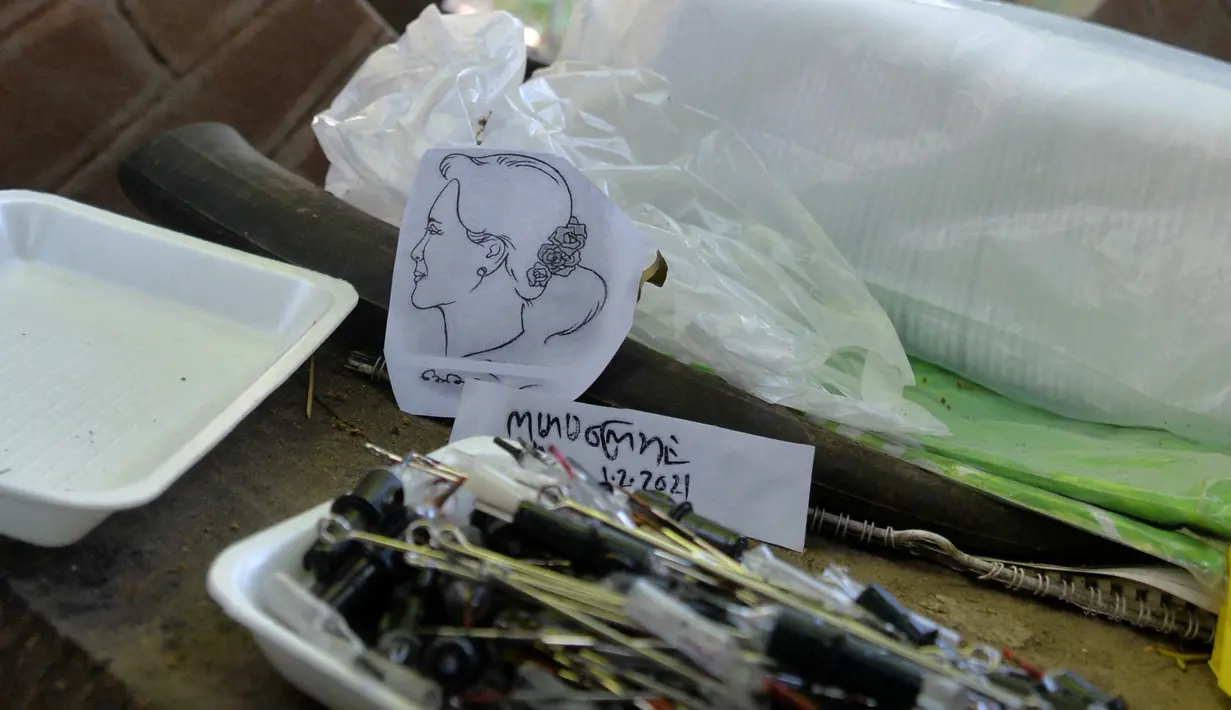 Skema tato pemimpin sipil Myanmar yang ditahan Aung San Suu Kyi digambarkan di sebuah salon tato di Naypyidaw, Rabu (10/2/2021). Warga Myanmar mengecam kudeta yang dilancarkan militer, aksi protes pun dilakukan melalui berbagai cara termasuk merajah tubuh. (STR/AFP)