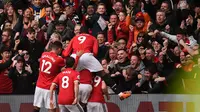 Ilustrasi para pemain Manchester United (MU) saat merayakan gol di hadapan pendukungnya. (Oli SCARFF / AFP)