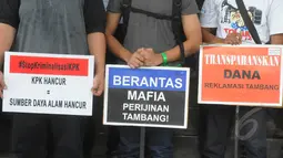 Sejumlah aktivis Koalisi Anti Mafia Tambang membentangkan poster saat menggelar aksi damai di halaman gedung KPK, Jakarta, Jumat (13/3/2015). Mereka menolak adamua dugaan kriminalisasi terhadap lembaga KPK. (Liputan6.com/Herman Zakharia)