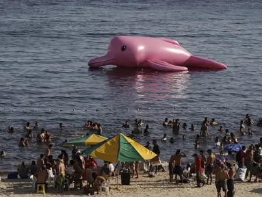 Sebuah lumba-lumba karet raksasa berwarna pink terlihat mengapung di pantai Ponta Negra, Manaus, Minggu (27/7/14). (REUTERS/Bruno Kelly)