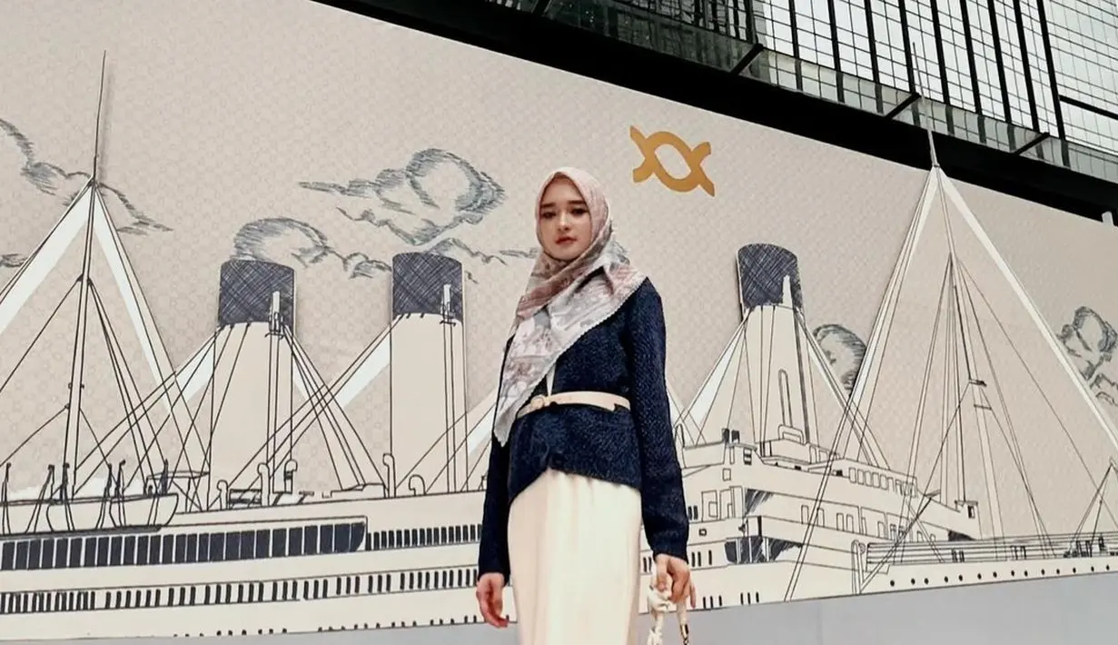 Tampil elegan ala Inara Rusli dengan padu padan loose dress putih, cardigan rajut, dan hijab bermotif. [Instagram/mommy_starla]