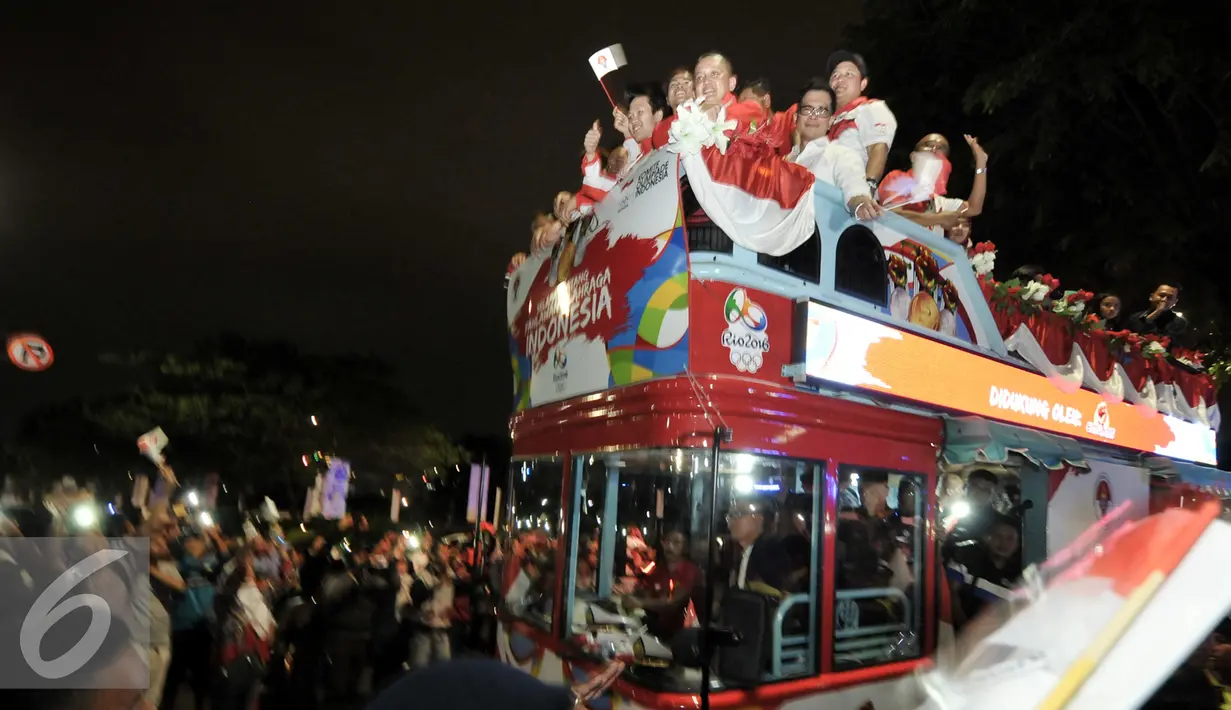 Arak-arakan atlet peraih medali Olimpiade Rio 2016 disambut meriah oleh warga, Senayan, Jakarta, Selasa (23/8). Setibanya di Tanah Air, atlet Olimpiade diarak menggunakan bus Bamdros menuju gedung Kemenpora. (Liputan6.com/Yoppy Renato)