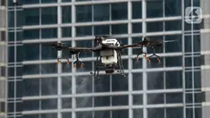Drone menyemprotkan cairan disinfektan di Jalan Bursa Efek menuju Patung  Pemuda, Jakarta, Jumat (27/3/2020). Penyemprotan dilakukan untuk mencegah penyebaran virus corona COVID-19. (merdeka.com/Imam Buhori)