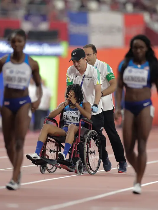 Sprinter Amerika Serikat, English Gardner menutupi wajahnya saat dibawa oleh tim medis akibat cedera dalam semifinal 100 meter putri Kejuaraan Atletik Dunia di Doha, Qatar, Minggu (29/9/2019). Peraih medali emas olimpiade tersebut mengalami cedera hamstring. (AP Photo/Petr David Josek)