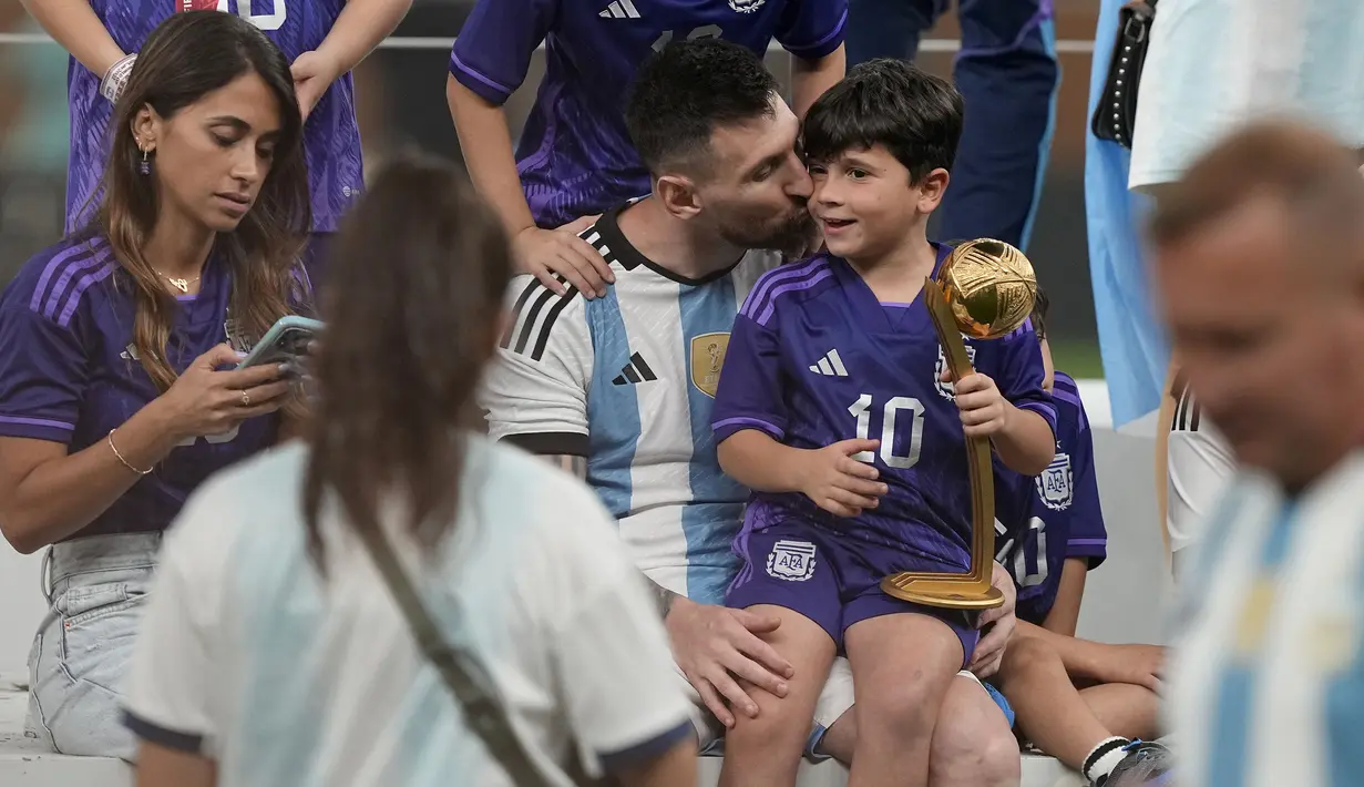 Pemain Argentina, Lionel Messi mencium anak ketiganya, Ciro saat merayakan kemenangan timnya di Piala Dunia 2022 setelah mengalahkan Prancis pada laga final yang berlangsung di Lusail Stadium, Qatar, Minggu (18/12/2022). Albiceleste menang 4-2 atas Prancis di babak penalti. (AP Photo/Martin Meissner)