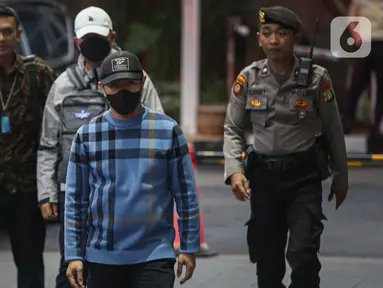 Penjabat (Pj) Wali Kota Pekanbaru, Risnandar Mahiwa (depan) dan Sekretaris Daerah Kota Indra Pomi Nasution (topi putih) saat tiba di Gedung Merah Putih Komisi Pemberantasan Korupsi (KPK), Jakarta, Selasa (3/12/2024). (Liputan6.com/Angga Yuniar)
