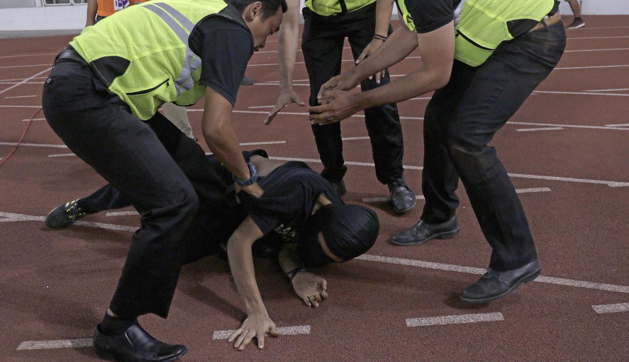 Suporter Timnas Indonesia diamankan petugas pengamanan ketika akan menghampiri suporter Malaysia saat laga Kualifikasi Piala Dunia 2022 di SUGBK, Jakarta, Kamis (5/9). (Bola.com/Peksi Cahyo)