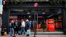 Orang-orang mengantre untuk memasuki toko andalan The Rolling Stones yang baru sebelum hari pertama pembukaannya di London, Rabu (9/9/2020). Rolling Stones membuka membuka toko pertamanya di 9 Carnaby Street. (Tolga Akmen / AFP)