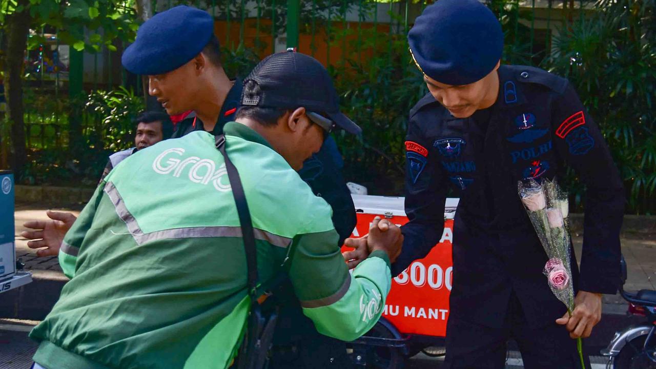 FOTO: Aksi Damai Ojol Tebar Mawar untuk Perdamaian