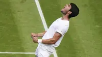 Petenis muda asal Spanyol, Carlos Alcaraz berselebrasi setelah mengalahkan Holger Rune dari Denmark pada pertandingan tunggal putra perempat final kejuaraan tenis Wimbledon di London, Rabu (12/7/2023).  (AP Photo/Alberto Pezzali)