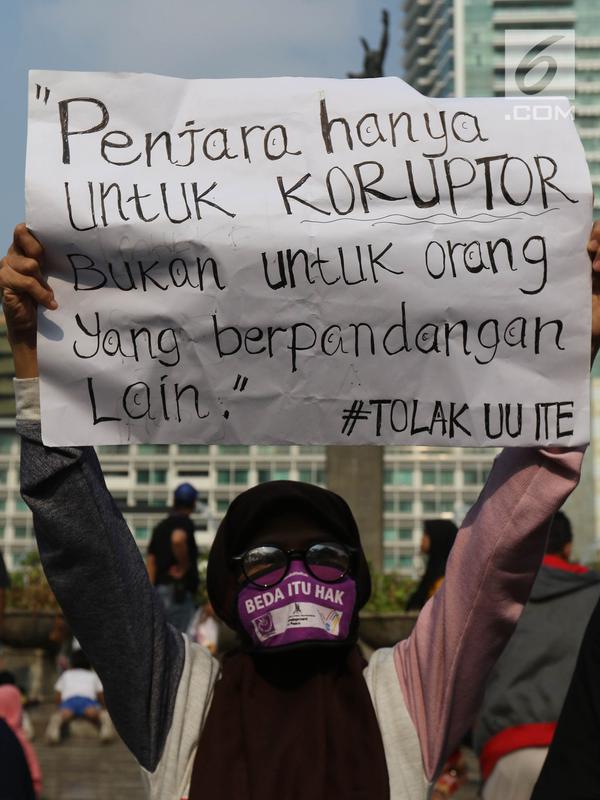 Jurnalis yang tergabung dalam Aliansi Jurnalis Independen (AJI) menunjukkan poster saat menggelar aksi menuntut pencabutan status tersangka Dandhy Dwi Laksono pada Car Free Day di Kawasan Bundaran HI, Jakarta, Minggu (29/9/2019). (Liputan6.com/Herman Zakharia)