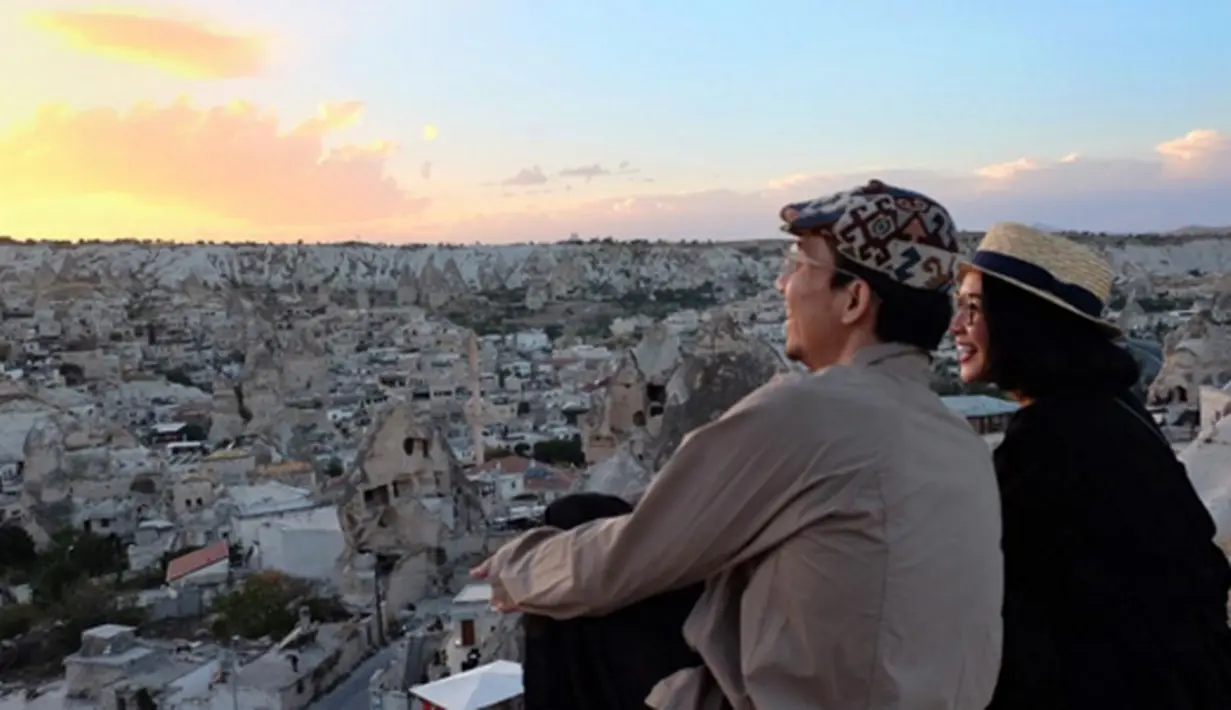 Andien dan Ippe menatap keindahan Goreme, nama lembah dan nama sebuah kota di Turki yang terletak di provinsi Nevsehir di Cappadocia. Mereka sejenak bersantai menikmati senja. (via instagram/@andienippestory)