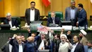Anggota parlemen Iran bersiap membakar dua lembar kertas bergambar bendera AS, Teheran, Iran, Rabu (9/5). Anggota parlemen Iran juga meneriakkan slogan-slogan menentang AS. (AP Photo)