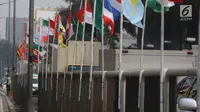 Deretan bendera negara-negara peserta Asian Games 2018 yang diikat di tiang bambu di pagar pembatas Jalan Pluit Selatan Raya, Jakarta, Kamis (19/7). Pemasangan bendera itu sempat menuai kritikan warganet di media sosial. (Liputan6.com/Arya Manggala)