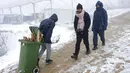 Seorang imigran membawa kayu bakar dalam tempat sampah di Kamp Lipa, luar Bihac, Bosnia, Jumat (8/1/2021). Cuaca bersalju dan musim dingin telah membawa lebih banyak penderitaan bagi ratusan imigran yang terjebak selama berhari-hari di kamp tersebut. (AP Photo/Kemal Softic)