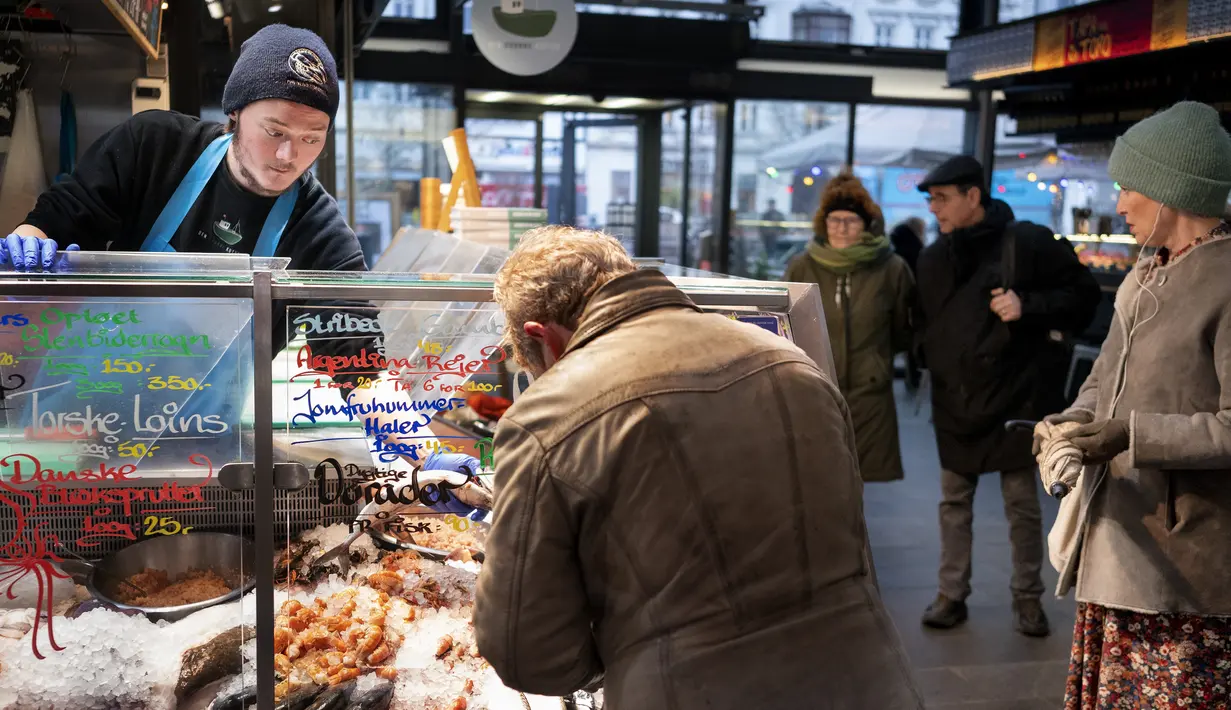 Pelanggan di pasar ikan di Torvehallerne di Kopenhagen, Denmark, Selasa (1/2/2022). Otoritas Kesehatan Denmark saat ini "merekomendasikan" mereka yang dites positif untuk diisolasi selama empat hari, sementara kasus kontak tidak perlu lagi dikarantina. (Liselotte Sabroe/Ritzau Scanpix via AP)