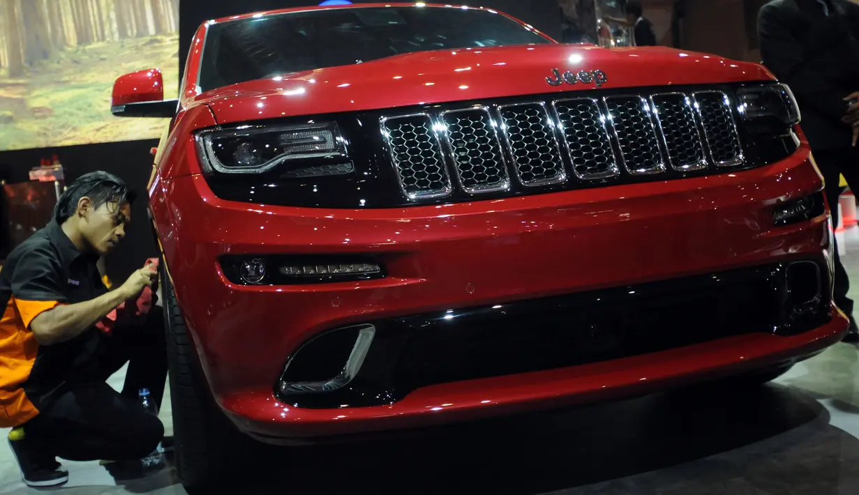 Pekerja membersihkan mobil Jeep Grand Cherokee yang dipamerkan di Indonesia Internasional Motor Show 2016 di JIEXPO Kemayoran Jakarta, Kamis (7/4/2016). Grand Cherokee tipe SR3 ini dibanderol Rp 2,850 M on the road. (Liputan6.com/Helmi Fithriansyah)