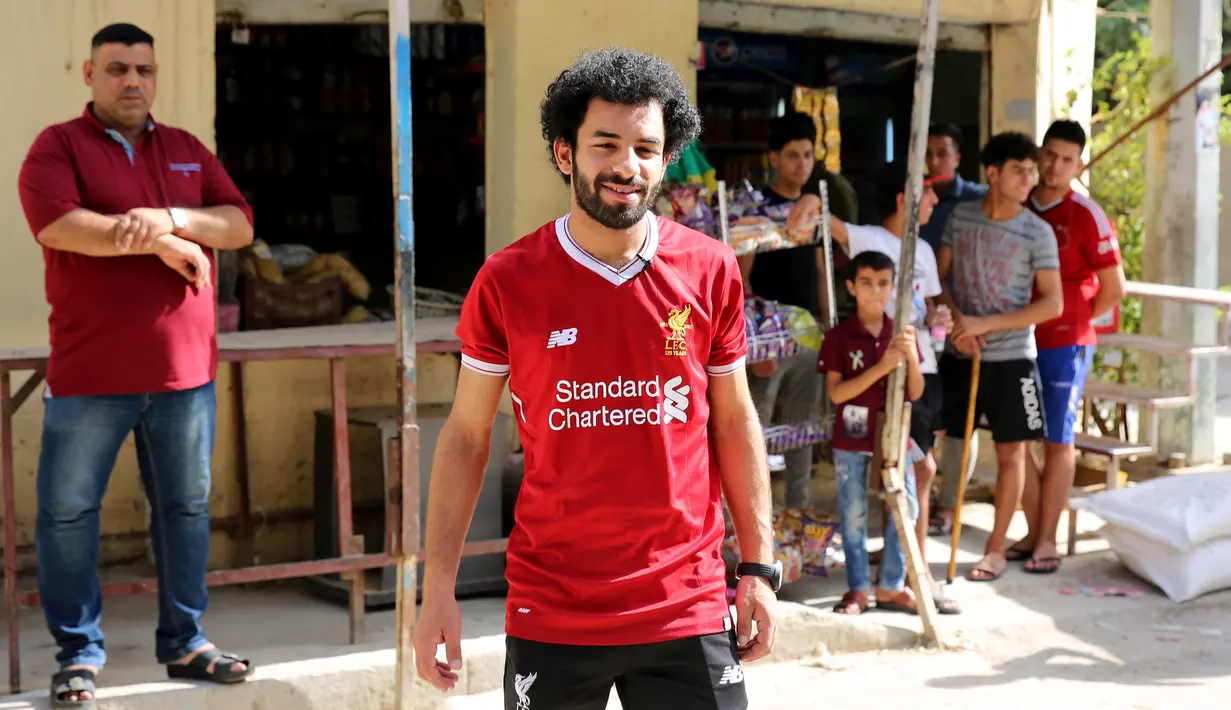 Pesepakbola Irak Hussein Ali berpose mengenakan kostum Liverpool di ibukota Baghdad (4/6). Hussein Ali merupakan pemain dari klub Irak Al-Zawraa FC yang mirip dengan bintang Liverpool, Mohamed Salah. (AFP Photo/Sabah Arar)
