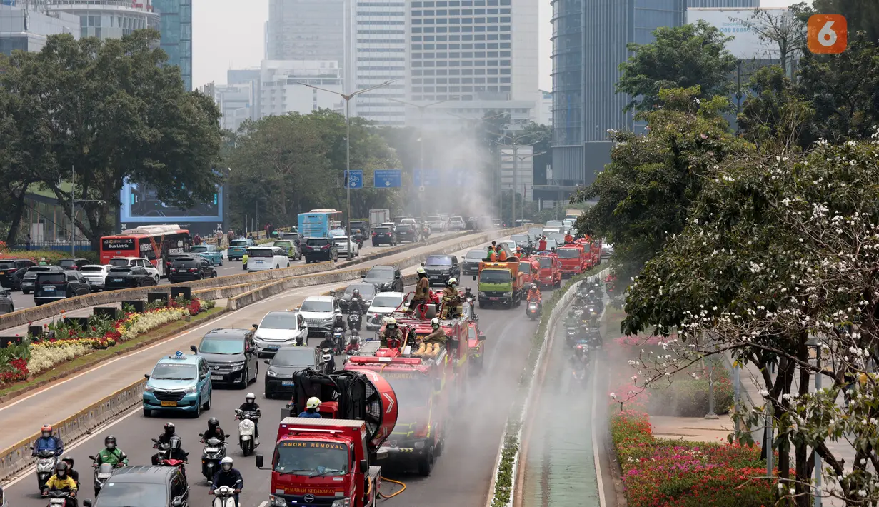 Petugas gabungan menyemprotkan air di kawasan jalan utama Jakarta yang terdampak sebaran abu vulkanik Gunung Anak Krakatau, sebagai langkah mengurangi partikel debu di permukaan jalan. (KLY/Budy Santoso)