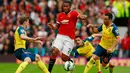 Gelandang Manchester United, Antonio Valencia (tengah) berusaha melewati dua pemain Arsenal saat Laga Liga Premier Inggris di Stadion Old Trafford, Minggu (17/5/2015). Manchester United bermain imbang 1-1 atas Arsenal. (Reuters/Jason Cairnduff)