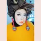 Tampilan Melly begitu nyentrik dengan sweater berwarna oranye dan headpiece yang unik dari Ms Fresh Lemonade by Moly. Hijab hitamnya dibalut headpiece berhiaskan ranting-ranting dan deretan buah keluek. (Instagram/melly_goeslaw)