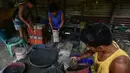 Para pekerja menyelesaikan pembuatan petasan di sebuah pabrik di Bocaue, Bulacan, Filipina, Jumat (27/12/2019). Petasan-petasan tersebut akan dijual untuk perayaan Tahun Baru 2020. (Maria TAN/AFP)