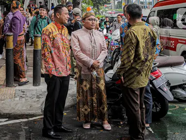 Keluarga pengantin yang menjalani resepsi di lantai 5 gedung K-Link Tower yang terbakar menunggu di trotoar Jl Gatot Subroto, Jakarta, Sabtu (15/7/2023). (Liputan6.com/Faizal Fanani)