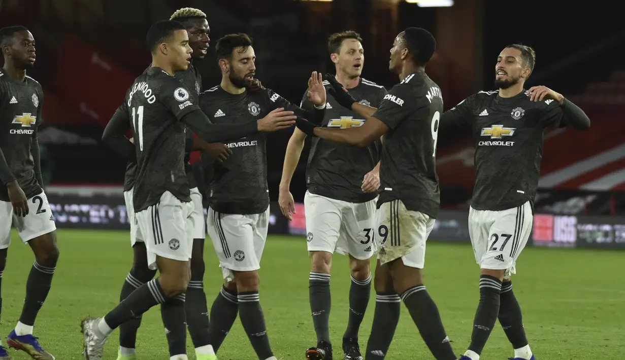 Penyerang Manchester United, Anthony Martial (kedua kanan) berselebrasi dengan rekannya usai mencetak gol ke gawang Sheffield United pada pertandingan Liga Inggris di stadion Bramall Lane di Sheffield, Inggris, Jumat (18/12/2020). MU tertinggal lima angka dari Liverpool di puncak klasemen. (AP Photo