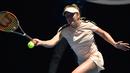 Petenis Ukraina, Elina Svitolina melakukan servis ke petenis Belgia Elise, Mertens di grand slam Australia Terbuka 2018, Selasa (23/1). Petenis cantik ini menarik perhatian karena tato di paha seksinya yang terlihat saat bertanding. (PETER PARKS/AFP)
