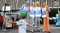 Tiga seniman egrang membawa poster Kampanye Aman Untuk Anak pada acara Deklarasi Pemilu Ramah Anak di Gedung Bawaslu, Jakarta, Minggu (17/3). KPU melarang anak-anak untuk terlibat dalam aktivitas kampanye politik. (Liputan6.com/Herman Zakharia)