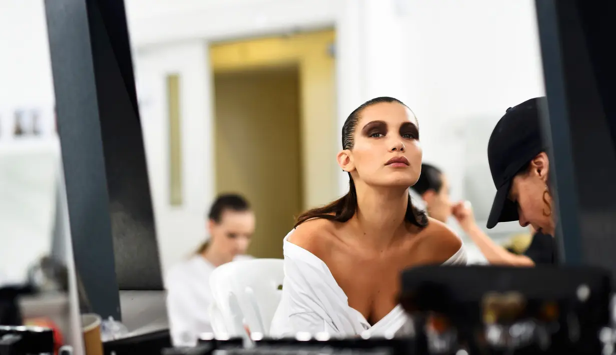 Bella Hadid, dipakaikan make-up saat di belakang panggung Blenheim Palace pada peragaan busana kolehsi Dior, Cruise 2017 di Woodstock, Inggris, 31 Mei 2016. Bella Hadid merupakan adik kandung dari model terkenal Gigi Hadid. (REUTERS / Dylan Martinez)