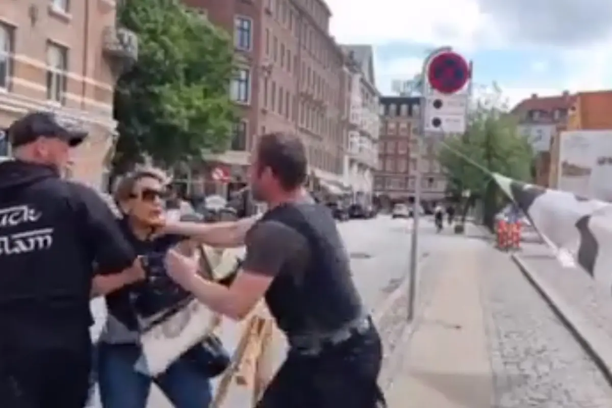 Wanita Denmark berusaha mencegah pembakaran Al-Qur'an. Ia diserang oleh penyelenggara, kemudian diamankan polisi.