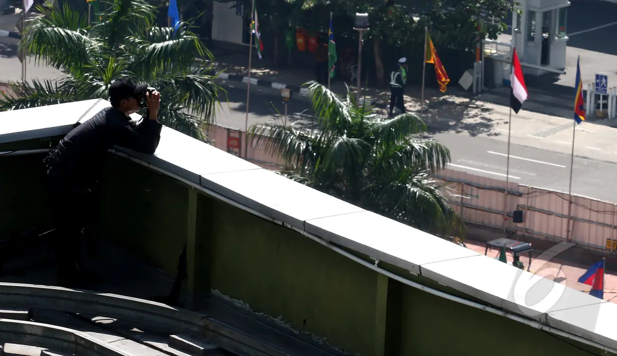 Penembak jitu (sniper) TNI menggunakan teropong mengawasi kawasan Bundaran HI, Jakarta, Senin (20/4). Dua puluh tujuh ribu personel TNI dikerahkan untuk menjaga keamanan KAA ke-60 di Kota Jakarta dan Bandung. (Liputan6.com/Johan Tallo)