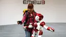 Petugas Hitachi Ltd berselfie dengan robot humanoid 'EMIEW 3' di Tokyo, Jepang, (8/4). Robot ini dikembangkan untuk memberikan layanan dan bimbingan yang diperlukan di toko-toko dan fasilitas umum. (REUTERS/Issei Kato)