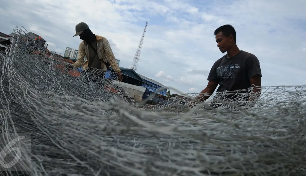 Pekerja menyelesaikan proyek jalan inspeksi Sungai Ciliwung di Cililitan Kecil, Jakarta, Kamis (22/12). Pembangunan jalan tersebut sebagai salah satu solusi mengatasi kemacetan di Ibukota dan normalisasi Sungai Ciliwung. (Liputan6.com/Gempur M Surya)