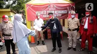 Seorang warga memberikan surat untuk mengikuti vaksin Covid-19 kepada petugas kepolisian berpakaian pejuang jaman dulu di Polsek Pasar Rebo, Jakarta, Selasa (17/8/2021). Para petugas berkostum pejuang jaman dulu memeriahkan HUT ke-76 Republik Indonesia. (Liputan6.com/Angga Yuniar)