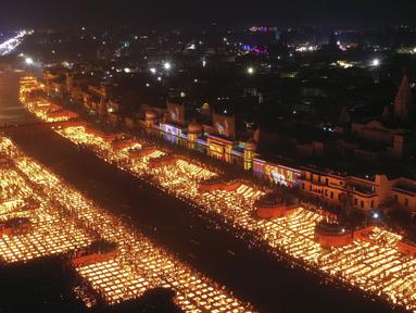 Orang-orang menyalakan lampu di tepi sungai Saryu di Ayodhya, India, Rabu (3/11/2021). Lebih dari 900.000 lampu minyak dinyalakan dan terus menyala selama 45 menit saat kota Ayodhya mempertahankan Rekor Dunia Guinness sebagai bagian dari perayaan festival Diwali. (AP Photo/Rajesh Kumar Singh)