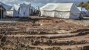 Para migran membersihkan tenda mereka, setelah hujan badai di kamp pengungsi Kara Tepe, di pulau Lesbos di timur laut Aegean, Yunani (14/10/2020).  (AP Photo/Panagiotis Balaskas)