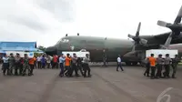 Barisan pengangkat peti jenazah berjalan menuju pesawat Hercules A-1320, Kalteng. Peti jenazah dikirim langsung ke Lanud TNI AL Juanda Surabaya, Kamis (1/1/2015). (Liputan6.com/Herman Zakharia)