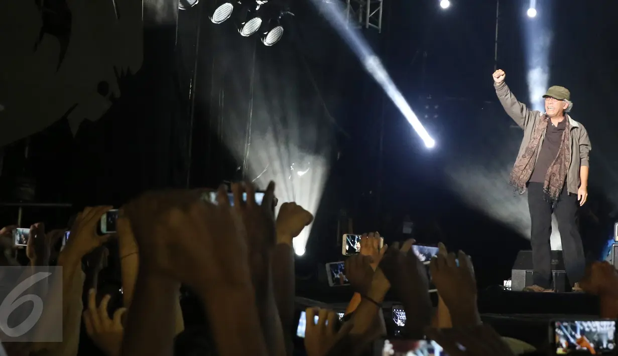 Musisi Iwan Fals menyapa para penonton pada konser Perayaan Karya Iwan Fals di Pantai Carnaval Ancol, Jakarta, Sabtu (03/9). Konser tersebut sebagai bentuk apresiasi dari perjalanan karir sang Iegenda musik Indonesia. (Liputan6.com/Herman Zakharia)