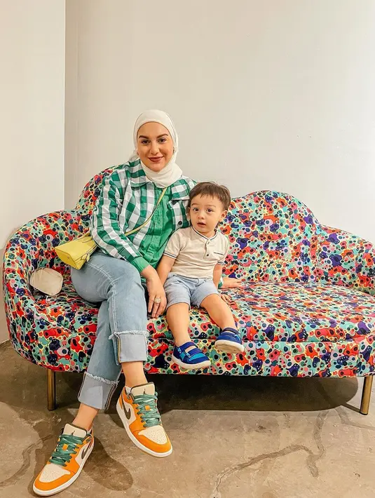 Irish Bella dan sang buah hati tampil lebih colorful. Irish terlihat mengenakan kemeja hijau yang ditumpuknya dengan flanel hijau-putih, dipadunya dengan celana jeans, dan hijab berwarna putih. Ia juga tampak mengenakan sneakers dan sling bag kuning. Sedangkan putranya tampil lebih kasual dengan atasan cokelat muda dan celana jeans pendek, serta sepatu biru. Foto: Instagram.