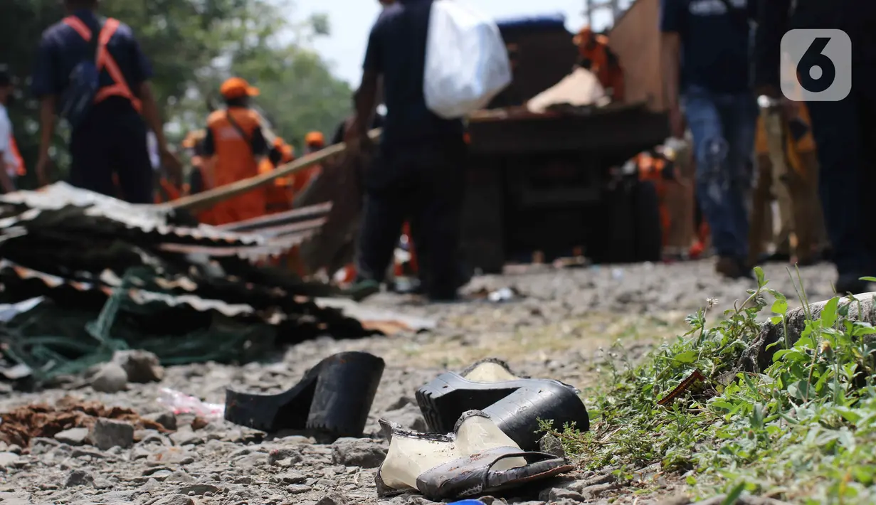 Sepatu tergeletak di jalan saat pembongkaran bangunan lokalisasi liar Gunung Antang di Matraman, Jakarta Timur, Selasa (30/8/2022). Ketika proses pembongkaran dilakukan, tidak ada perlawanan dari penghuni lokalisasi liar tersebut. (Liputan6.com/Herman Zakharia)