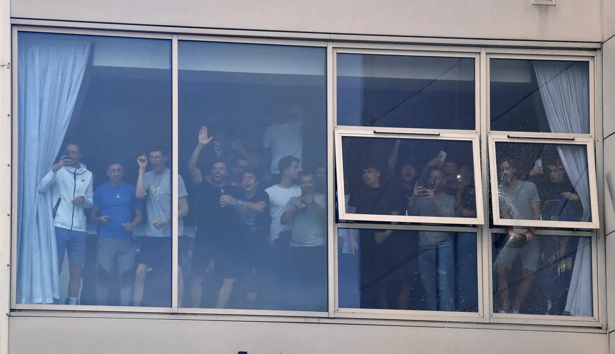 Para pemain Leeds United di sebuah jendela di dalam stadion menyapa pendukung mereka untuk merayakan kembalinya klub ke Liga Premier setelah 16 tahun, di Leeds, Inggris utara (17/7/2020). (AFP/Paul Ellis)