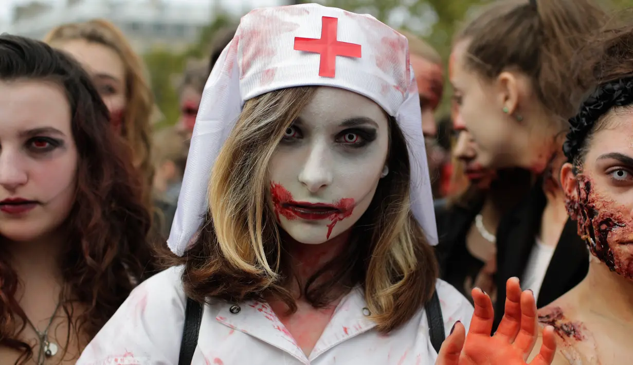 Seorang wanita mengenakan kostum suster bergaya zombie berpose saat mengikuti "Zombie Walk" di Paris, Prancis (7/10). (AFP Photo/Thomas Samson)