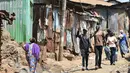 Henry Ohanga alias Octopizzo (tengah) berjalan dengan seorang teman saat berkunjung ke Kibera di Nairobi, Kenya (16/1). Seperti kebanyakan anak muda di daerah kumuh ini, Octopizzo berpikir dia tidak akan pernah menjadi apa-apa. (AFP Photo/Tony Karumba)